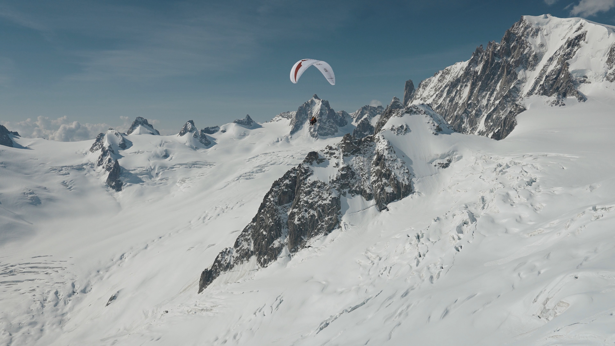 Paraglider over a snowy ridge